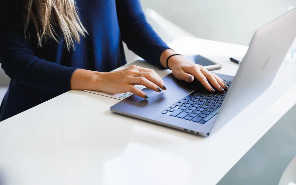 Content writer typing an SEO blog post on a laptop at a white desk